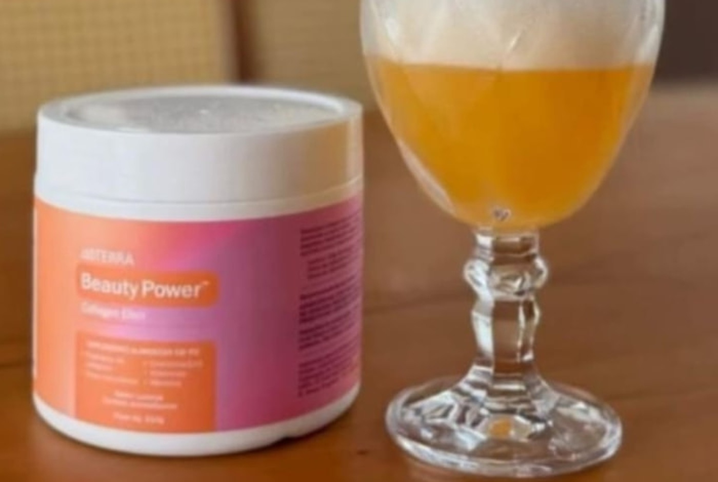 Pote do Beauty Power ao lado da bebida preparada, com cor dourada alaranjada